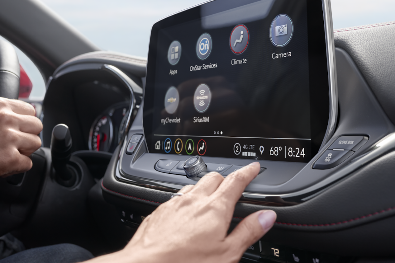 A person reaching for the infotainment system in the 2024 Chevrolet Blazer sporty mid-size SUV.