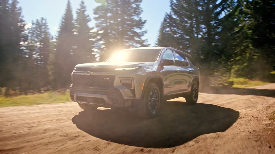 2024 Chevrolet Traverse driving alone on a dusty dirt road.