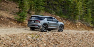 Side Profile View of the 2024 Chevy Traverse Driving on a Gravel Path