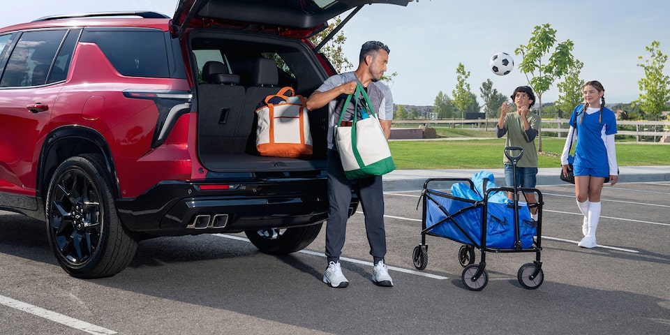 A man packing his trunk with sports equipment in his 2024 Chevrolet Traverse.