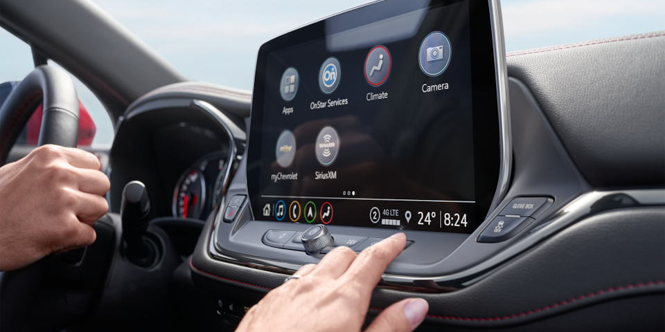 Side view of a person's hand touching the infotainment screen of the 2025 Chevrolet Blazer.