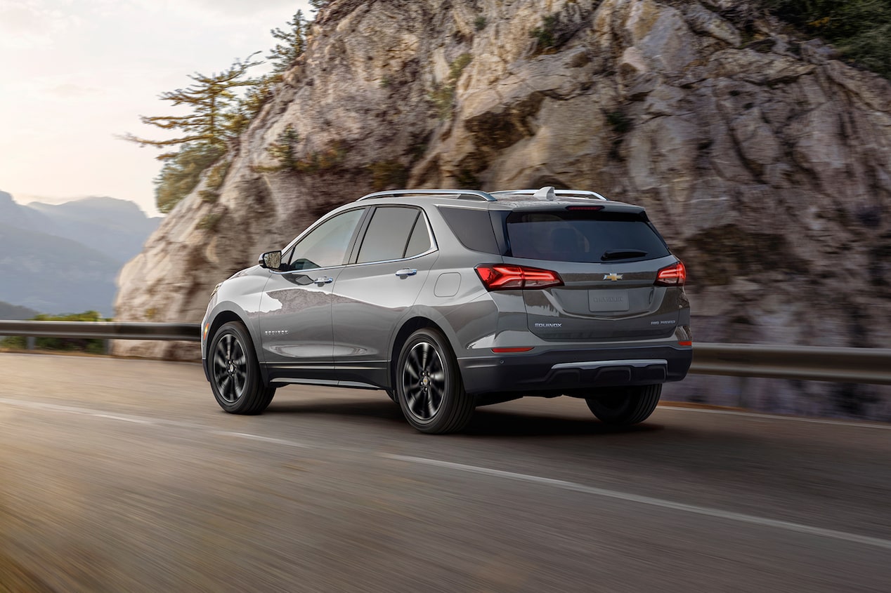 A view of the athletic rear-end design of the 2024 Chevrolet Equinox as it cruises on an open mountain road.