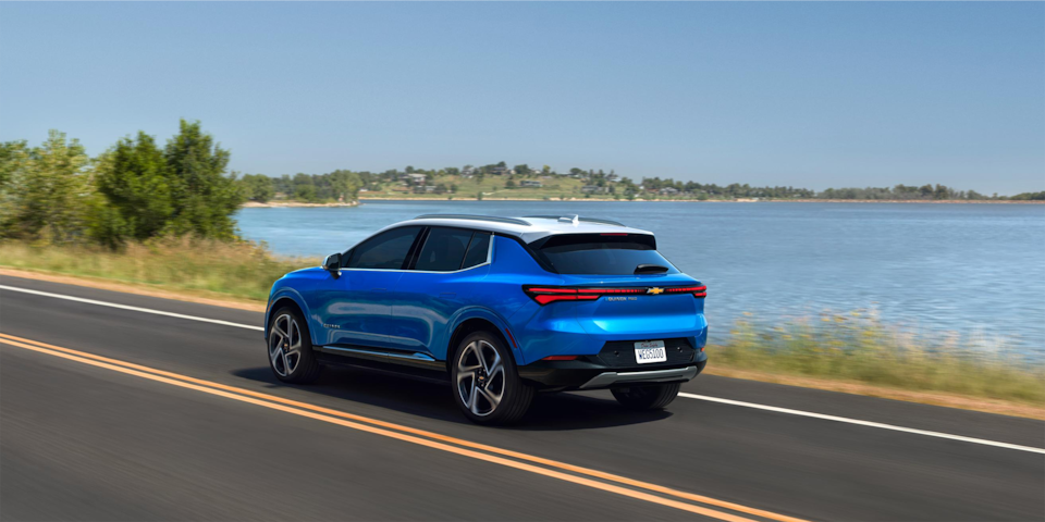 2024 Chevrolet Equinox EV driving by a lake.