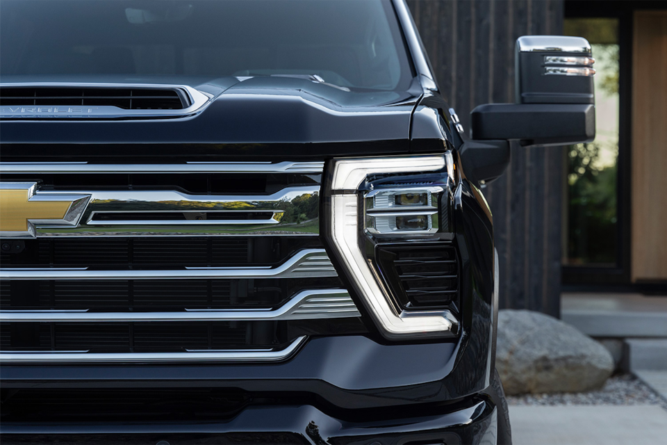 Front view of the 2025 Chevrolet Silverado HD pickup truck parked outside a home.