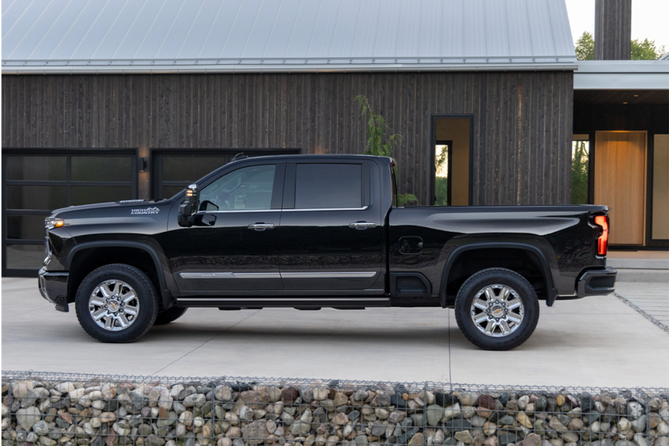 Side view of the 2025 Chevrolet Silverado HD pickup truck parked outside a home.