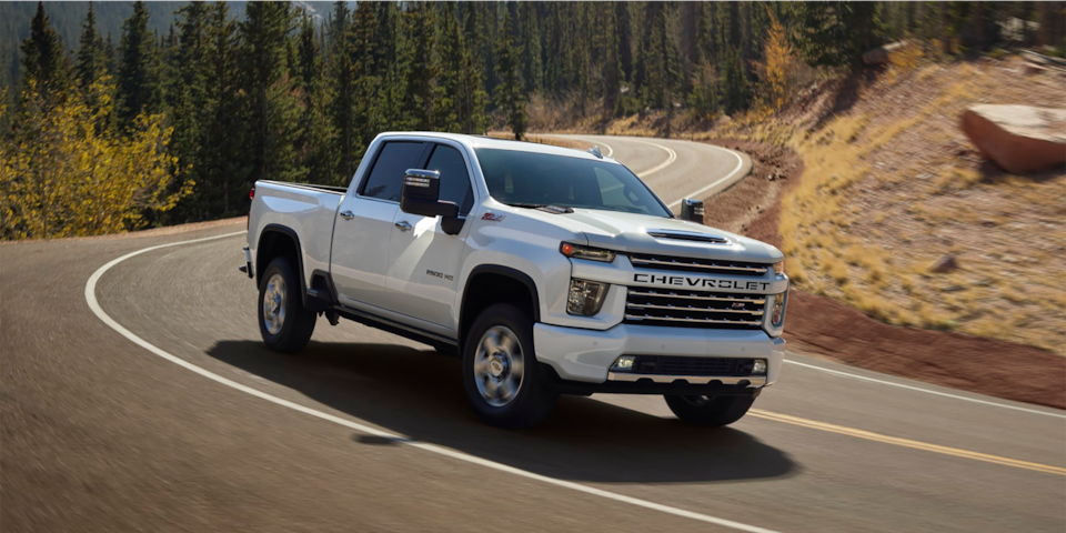 Front-side view of the 2025 Chevrolet Silverado HD driving alone on the road.