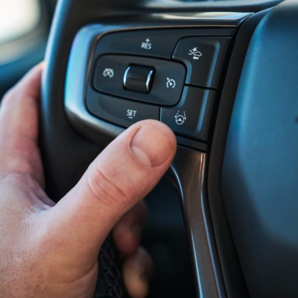 A person's thumb on the Super Cruise activator button of the 2025 Chevrolet Silverado LD.