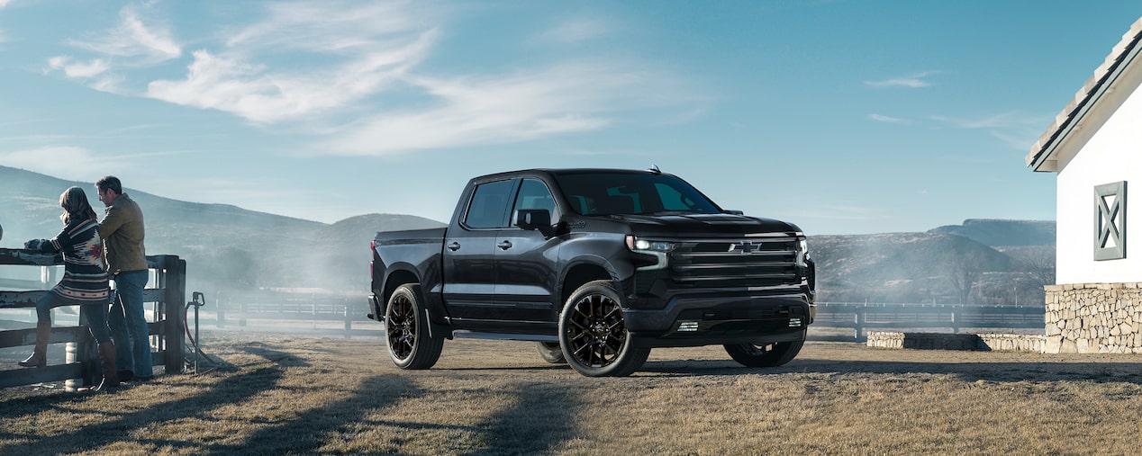 Vue latérale avant du Chevrolet Silverado LD 2025 stationné devant une maison de campagne.