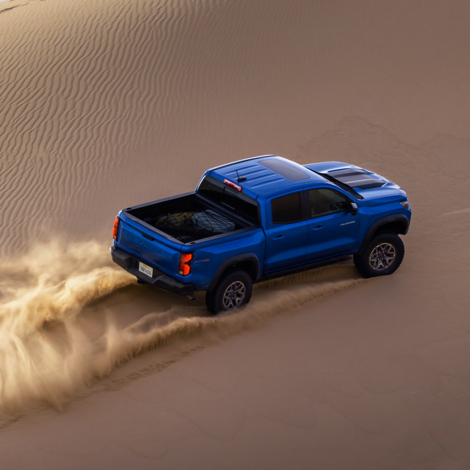 Vue aérienne d’un camion Chevrolet ZR2 qui roule à toute allure en conduite hors route sur un terrain sablonneux.