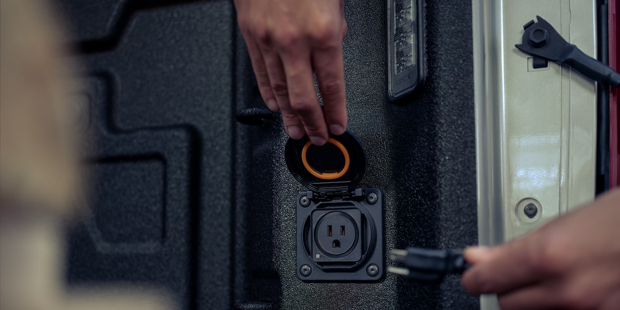 Closeup view of the electrical outlet in the cargo bed of the 2024 Chevrolet Silverado work truck.