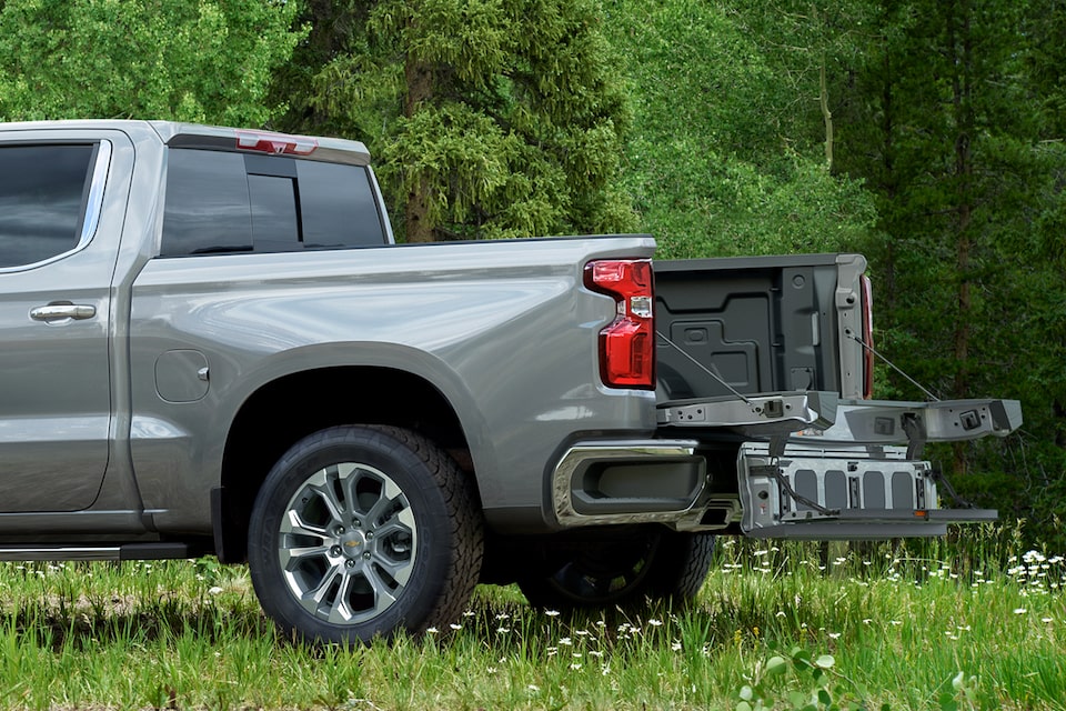 2024 Chevrolet Silverado work truck parked on the grass with its tailgate lowered.