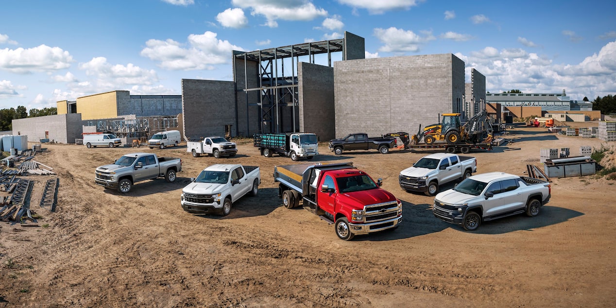 Several Chevrolet Silverado work trucks parked at a construction site.