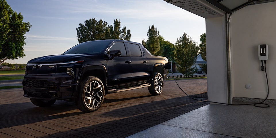 Un Chevrolet Silverado EV en train d’être rechargé à une borne de recharge résidentielle.