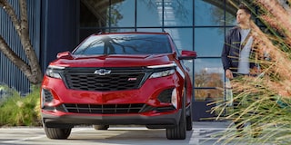 A man parks his 2024 Chevrolet Equinox RS in front of his office building.