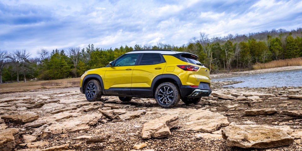 Side view of the 2024 Chevrolet Trailblazer parked on a rugged terrain by the lakeside.