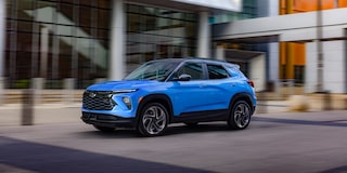 The 2024 Chevrolet Trailblazer driving past a modern building.