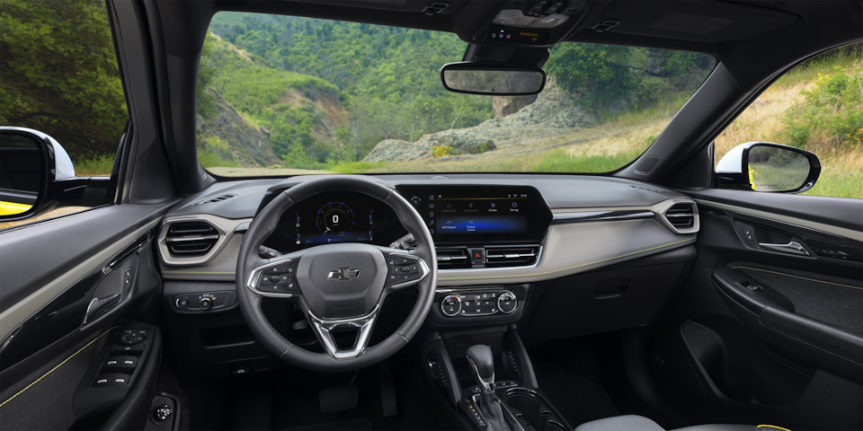 Rear passenger's view of the interiors of the 2024 Chevrolet Trailblazer parked on a hillside road.