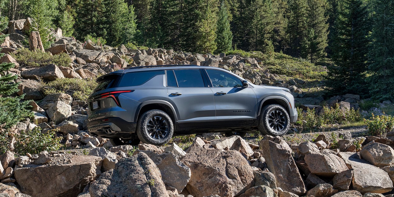 2024 Chevrolet Traverse driving uphill on a rocky path.