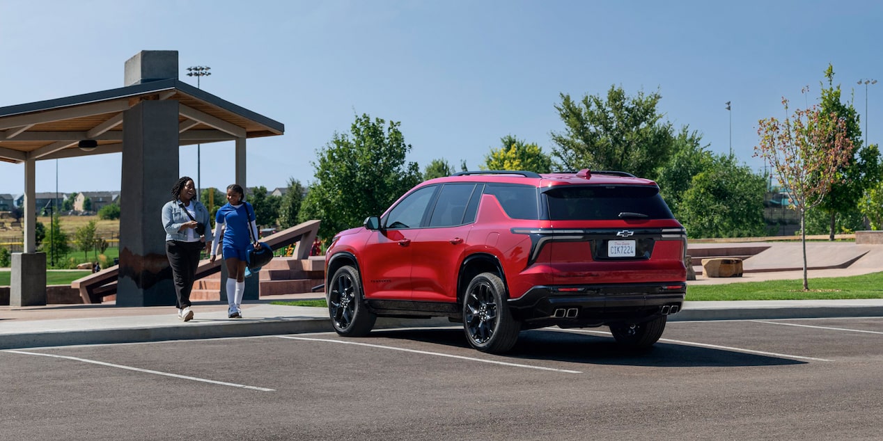 2024 Chevrolet Traverse parked outside a modern building.