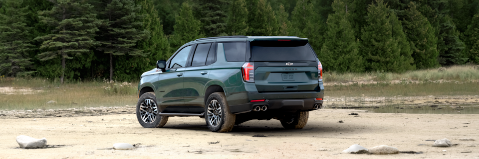 Vue latérale arrière du VUS Chevrolet Tahoe 2025 stationné sur du sable.