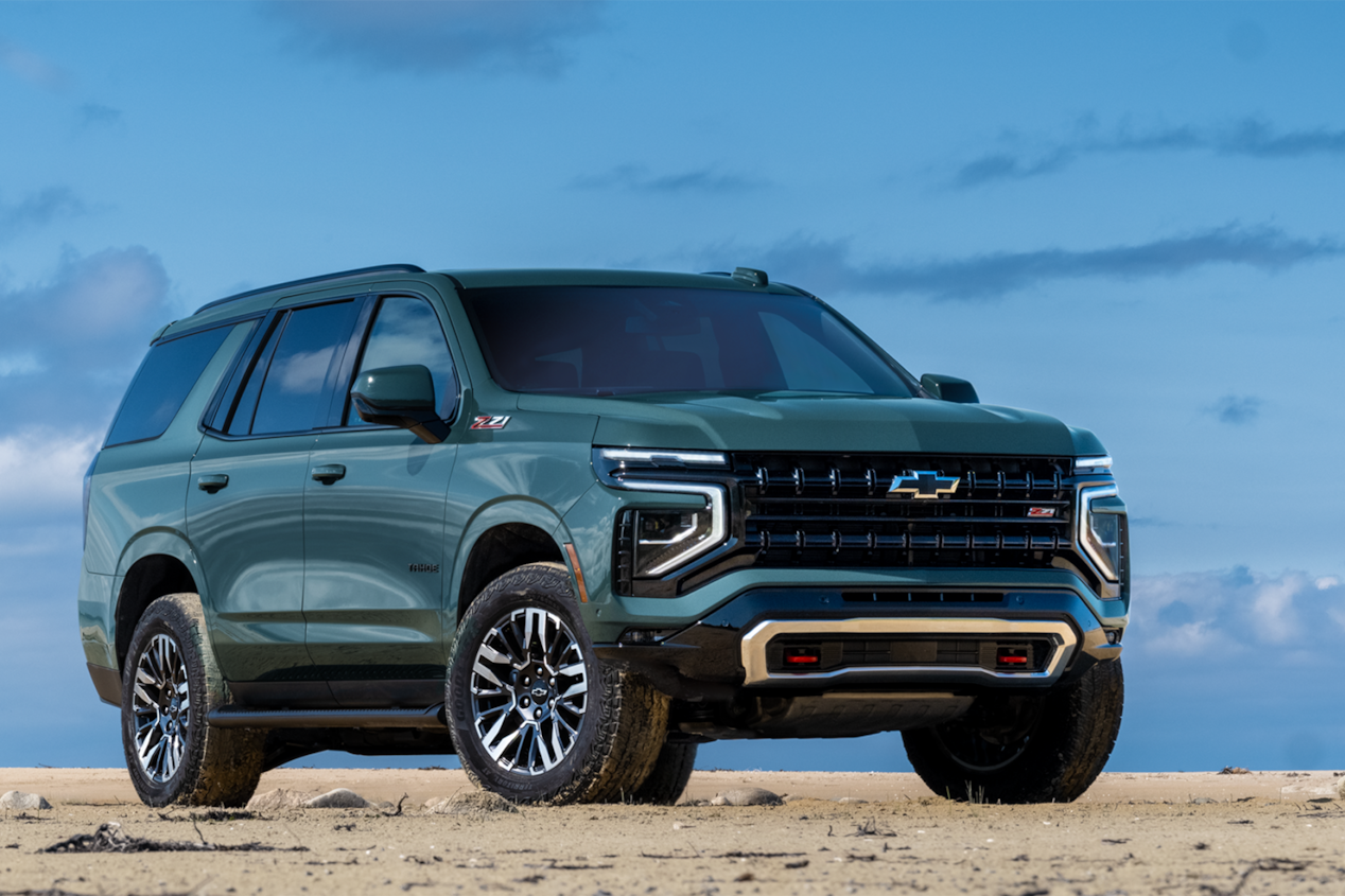 Vue latérale avant du VUS Chevrolet Tahoe 2025 stationné devant un lac.