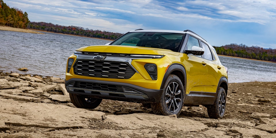 2025 Chevrolet Trailblazer driving on rocky terrain by the water.