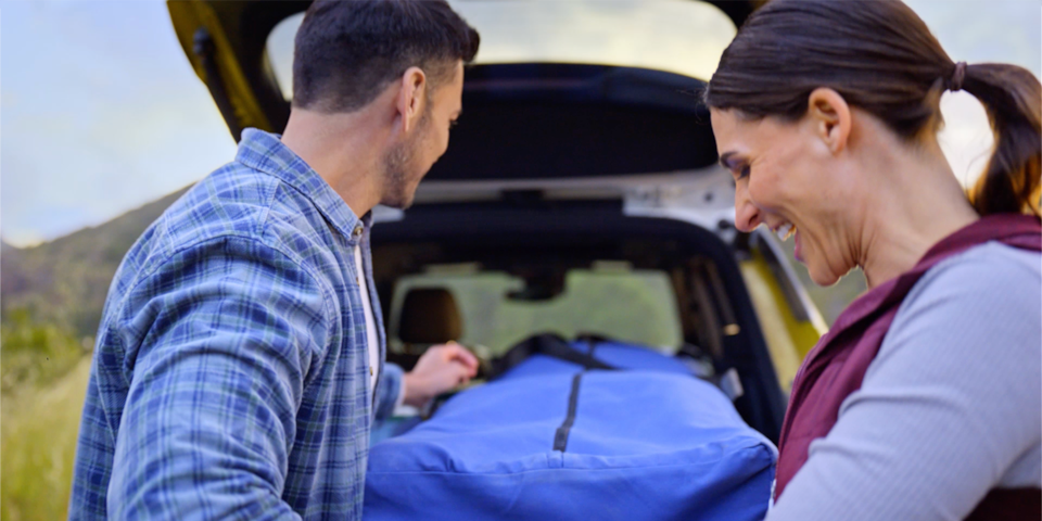 A Couple Loading Camping Gear in Trunk of the 2025 Chevrolet Trailblazer.