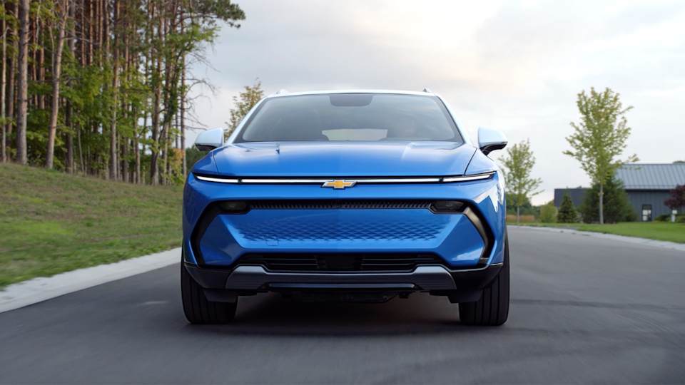 The 2024 Chevrolet Equinox EV driving down a street.