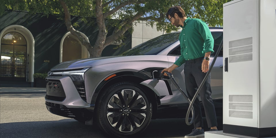 Vue latérale d’une personne en train de recharger un Chevrolet Blazer EV 2025.