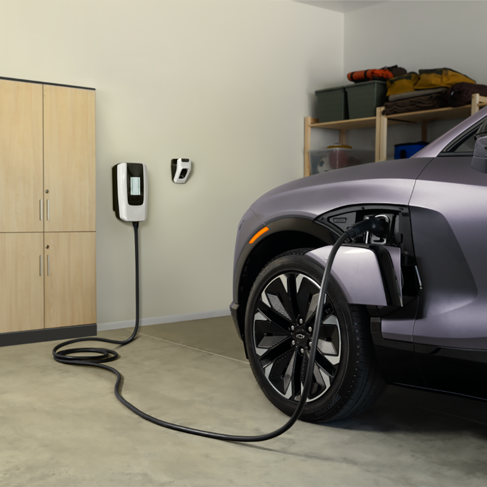 Front-side view of a 2025 Chevrolet Blazer EV getting charged at home.