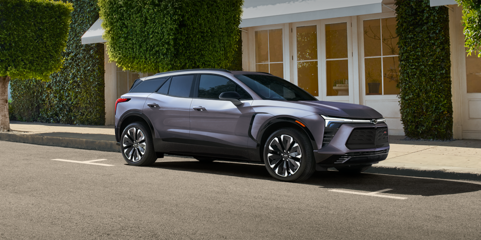 Three quarters view of the 2025 Chevrolet Blazer EV parked outside a house.