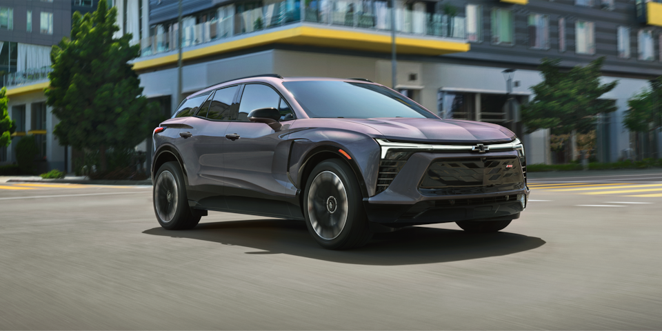 Three quarters view of a 2025 Chevrolet Blazer EV parked in front of a building.