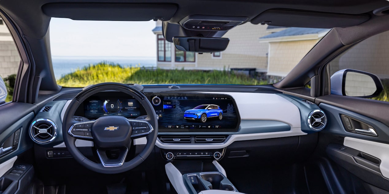 Vue de l’habitacle côté conducteur d’un Chevrolet Equinox EV 2025 stationné devant une maison.