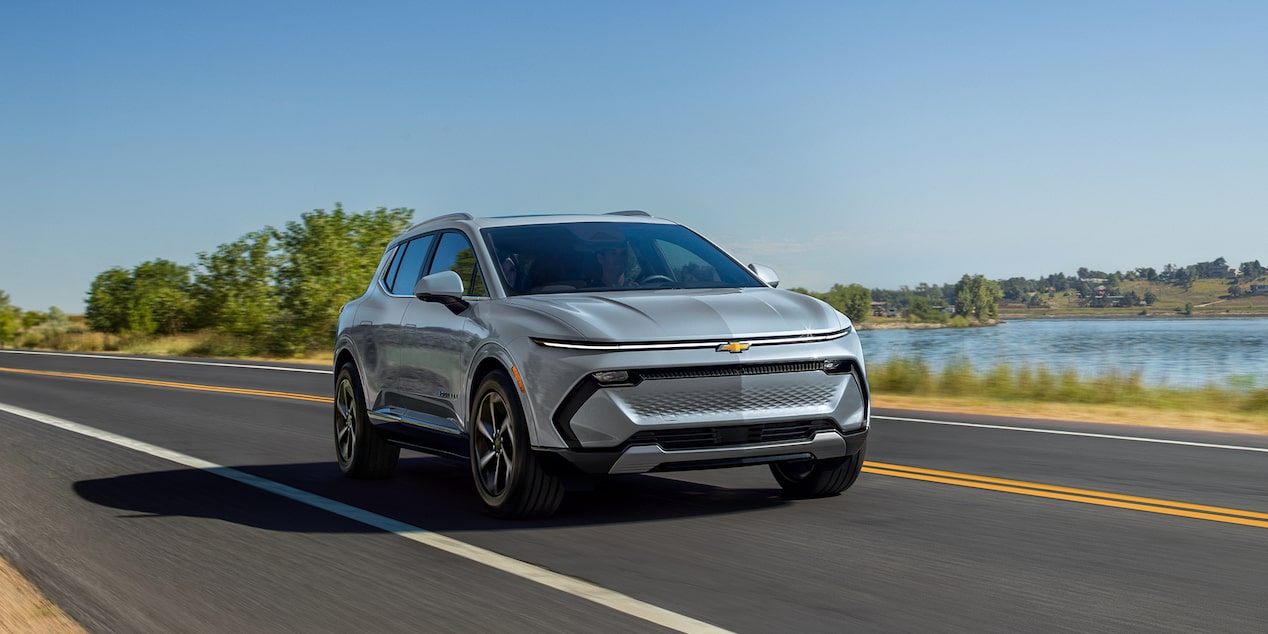 Front-side view of a 2025 Chevrolet Equinox EV driving down the road.