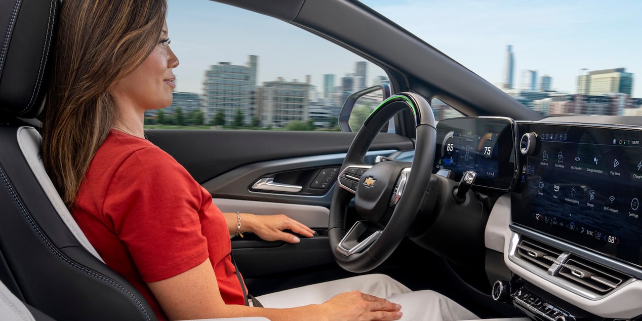 Une femme assise dans le siège du conducteur du Chevrolet Equinox EV 2025 vue par le passager avant.