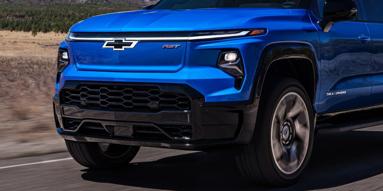 Front-side view of a 2025 Silverado EV driving down the road.