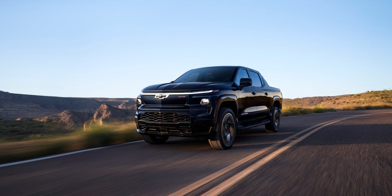 Front-side view of a 2025 Chevrolet Silverado EV driving down the road.