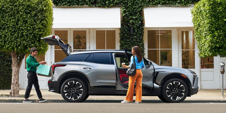 Two people loading shopping bags into their Chevrolet Blazer EV.