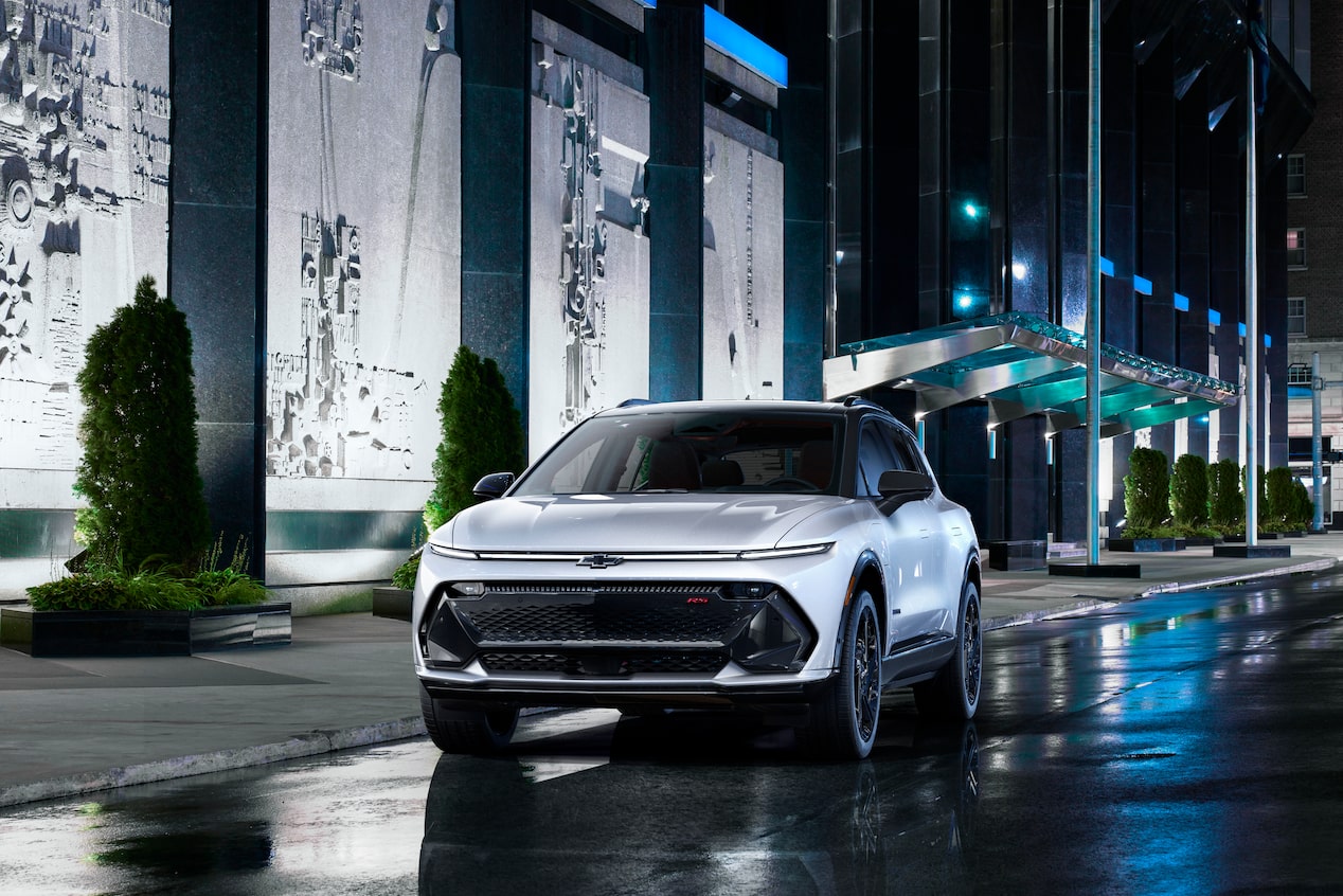 Front view of the Chevrolet Equinox EV parked near a sidewalk at night.