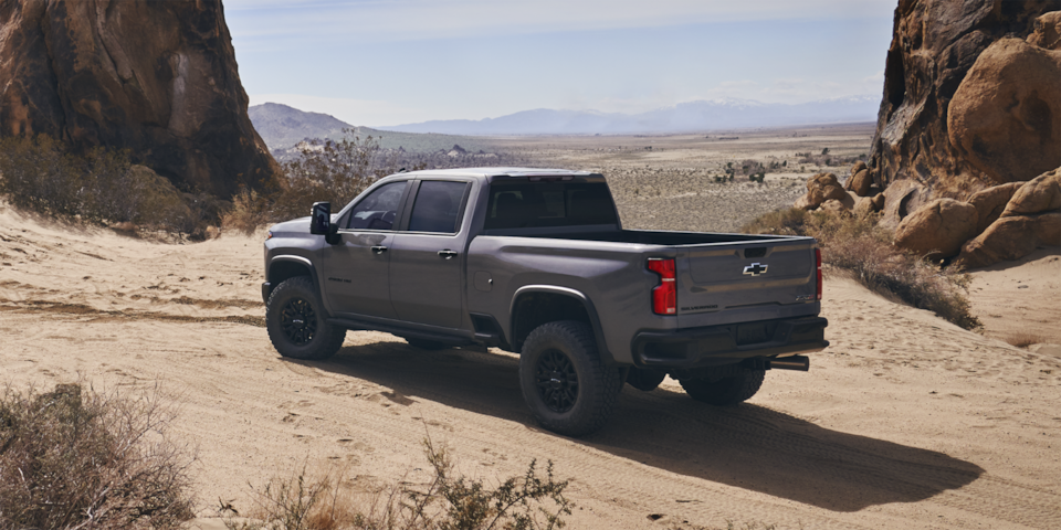 Back-side view of the 2025 Chevrolet Silverado HD pickup truck parked by a canyon.