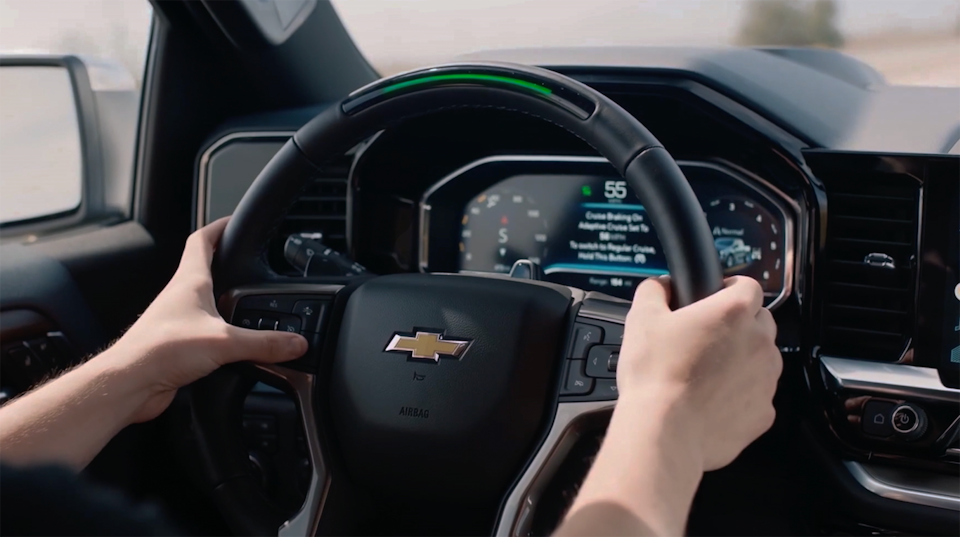 A person's hand holding the steering wheel of the 2025 Chevrolet Silverado LD.