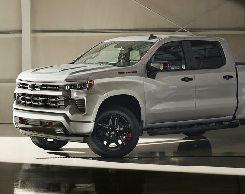 Vue latérale d’un Chevrolet Silverado LD 2025 gris stationné dans un garage.