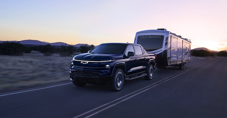 The 2024 Silverado EV towing a large RV camper.