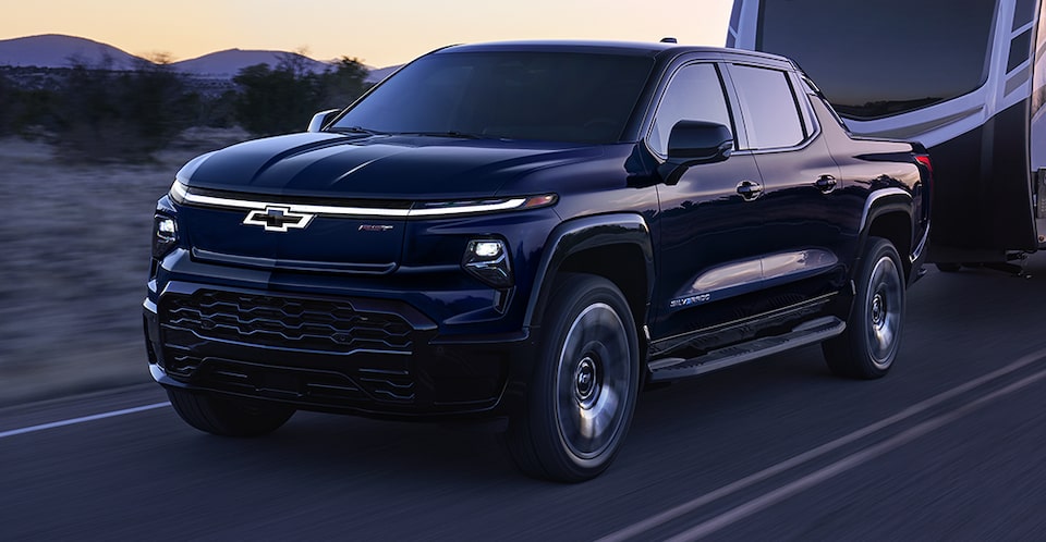 The 2024 Chevrolet Silverado EV towing a large RV camper.