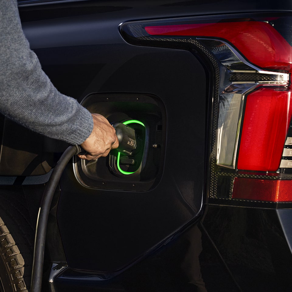 A person plugging in a 2024 Chevrolet Silverado EV into the charging station.