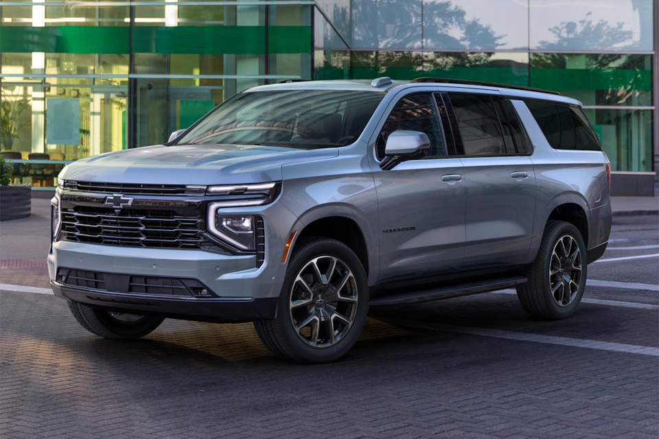 Front Three-Quarters View of the 2025 Chevrolet Suburban SUV Parked in Front of a Business