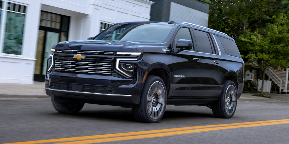 Front Three-Quarters View of the 2025 Chevrolet Suburban SUV Driving on a Road