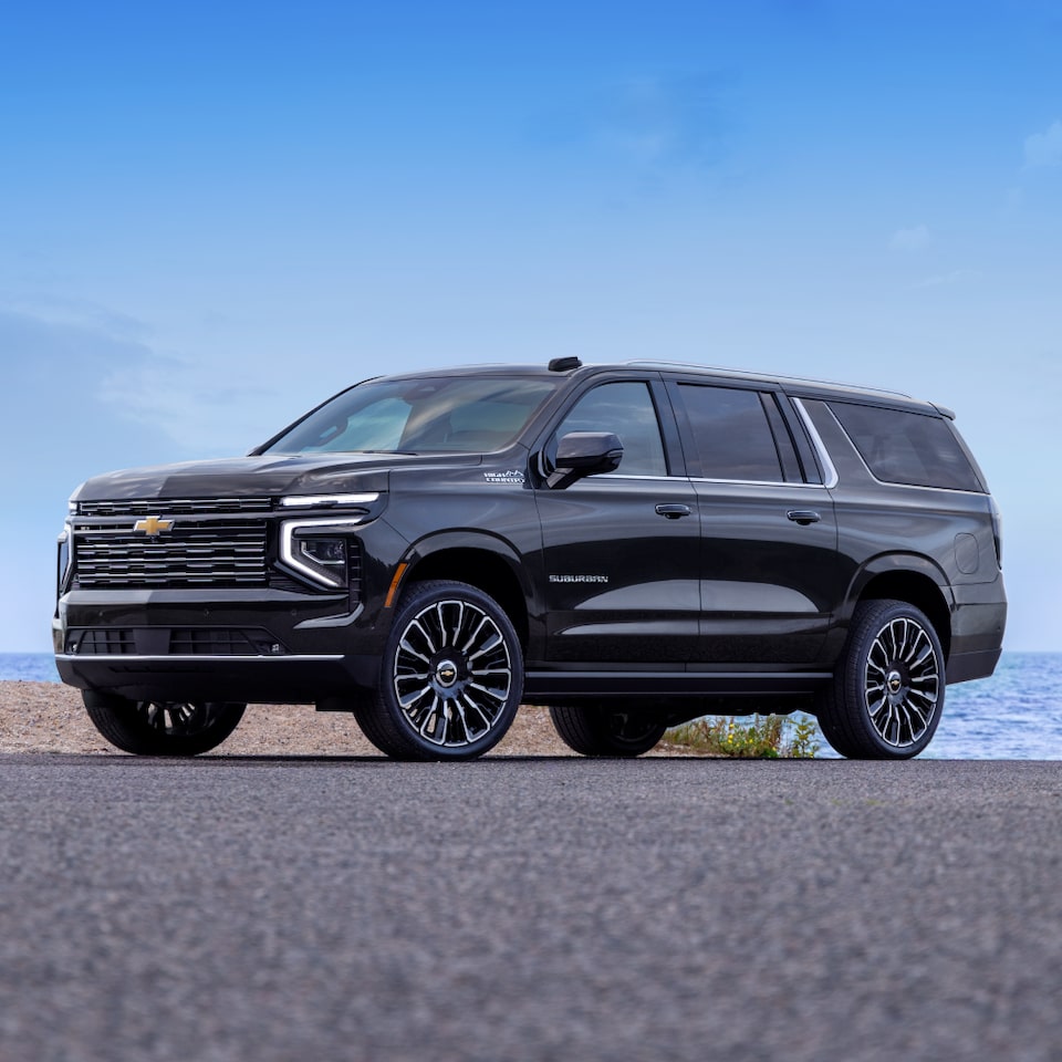 Front Three-Quarters View of the 2025 Chevrolet Suburban SUV Parked in Front of a Lake